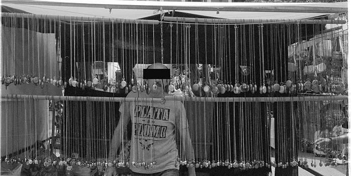 Collares colgados delante del vendedor en un puesto de El Rastro de Madrid