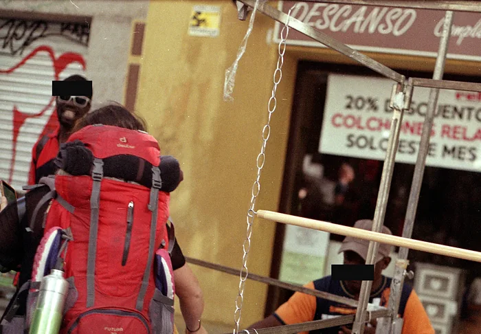 El rótulo de una tienda de colchones sobre la gente en El Rastro de Madrid