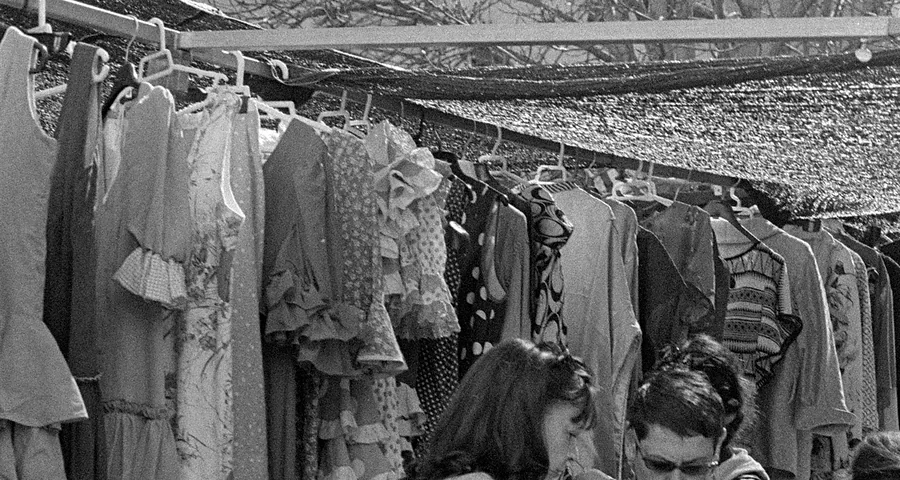 Vestidos colgados de la percha de un puesto de El Rastro de Madrid