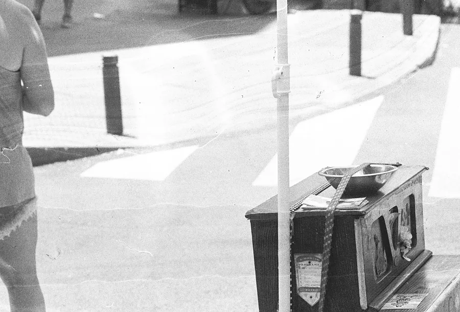 Una organillera sentada en el paso de cebra de El Rastro de Madrid