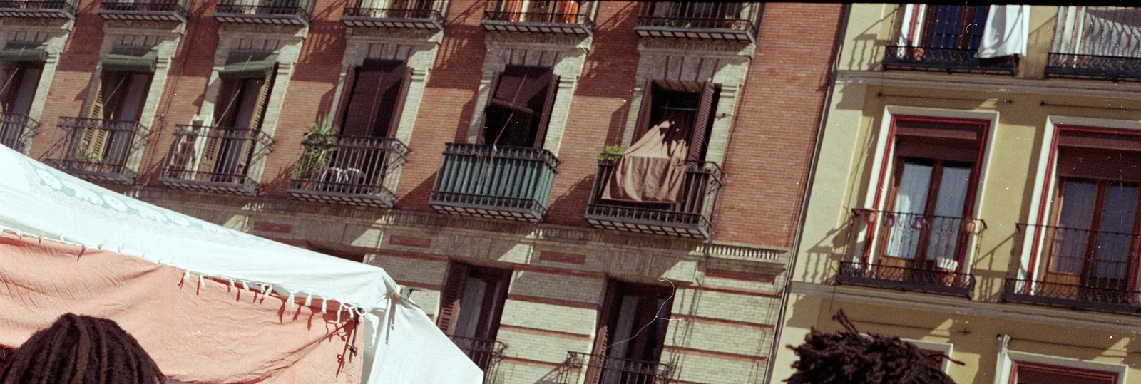 Los toldos de los puestos bajo los balcones de El Rastro de Madrid